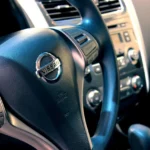 Mechanic and car owner inspecting a car steering wheel and dashboard in a garage
