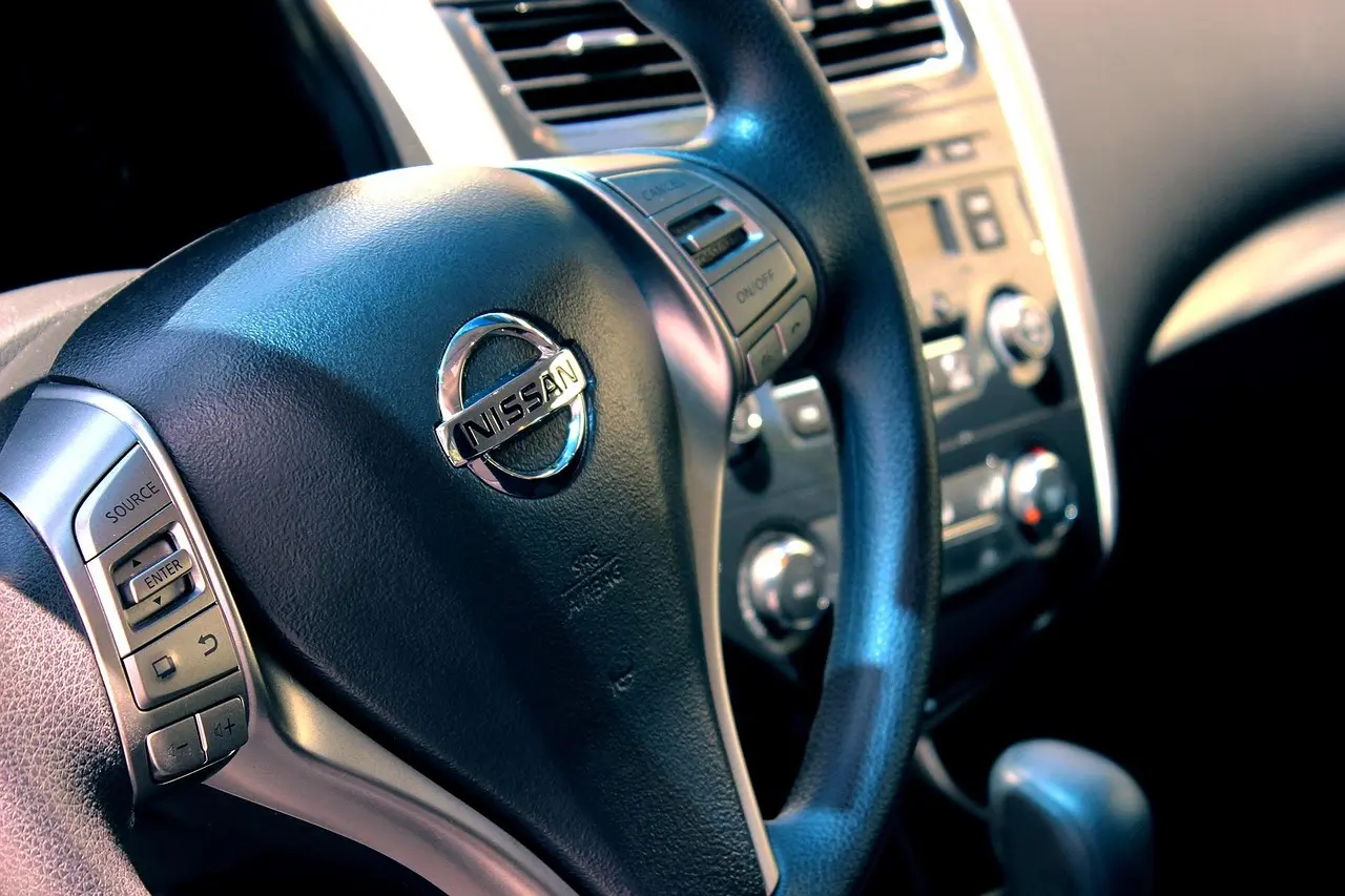 Mechanic and car owner inspecting a car steering wheel and dashboard in a garage