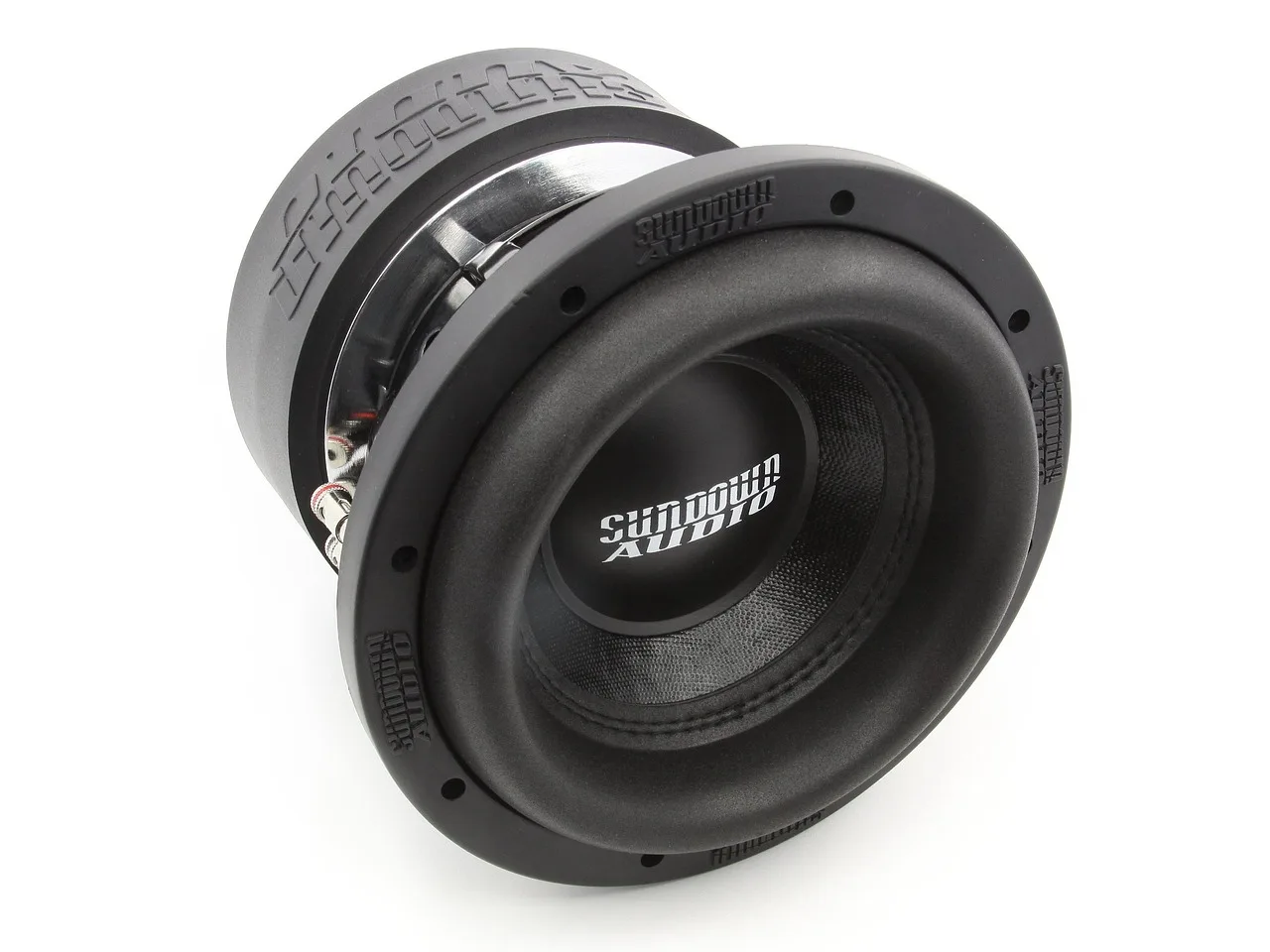 A car audio enthusiast compares two subwoofer boxes in a garage with a larger enclosure beside a smaller one.