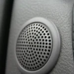 Car door interior with a component speaker set beside the factory speaker location