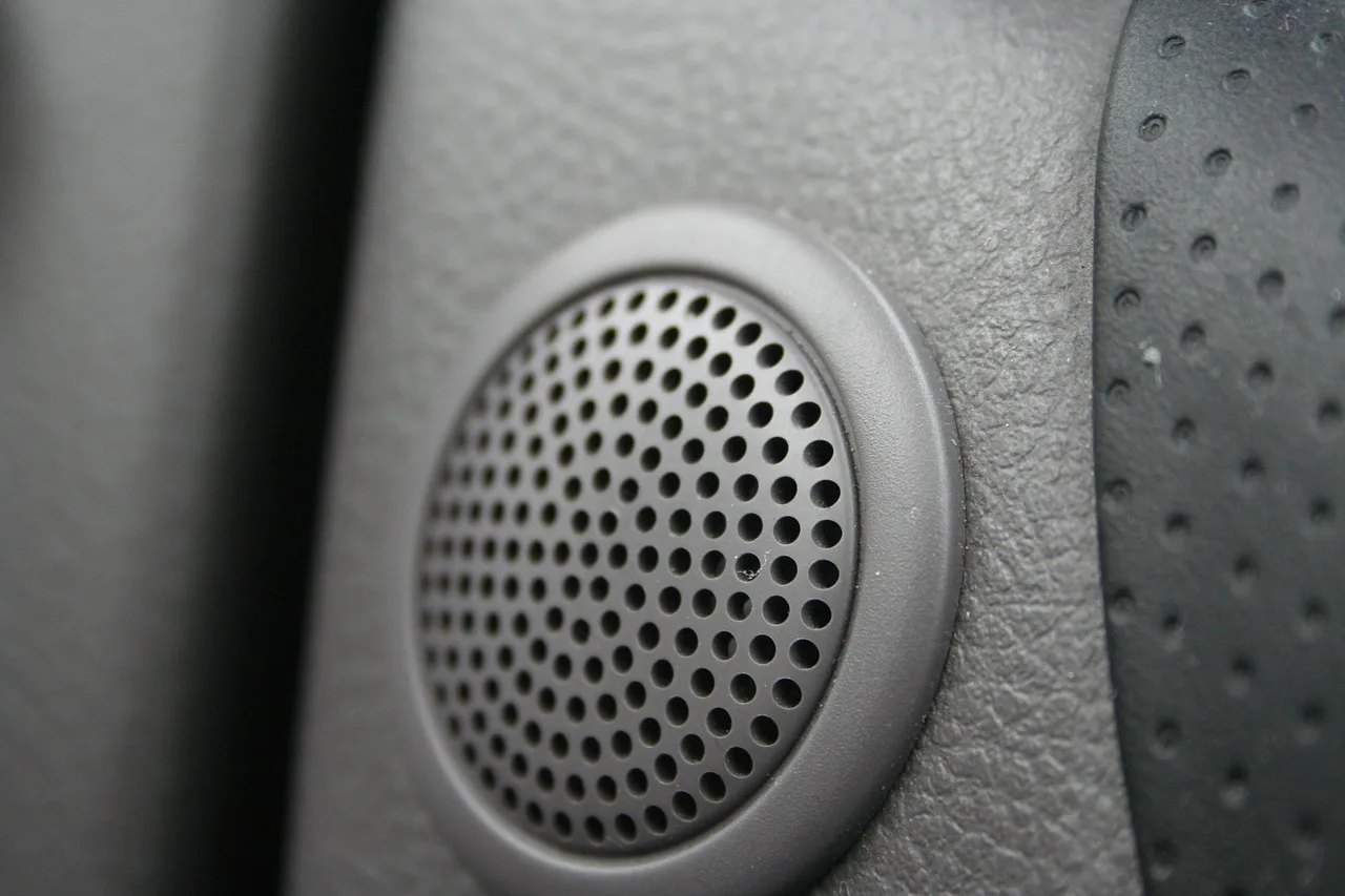 Car door interior with a component speaker set beside the factory speaker location
