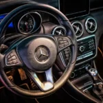 Driver pressing steering wheel controls in a car interior with the radio dashboard visible