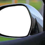 Driver compares a rearview mirror monitor and wiring options beside an open car door.