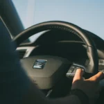 Car installer tracing steering wheel controls wiring beside an aftermarket stereo in a vehicle interior