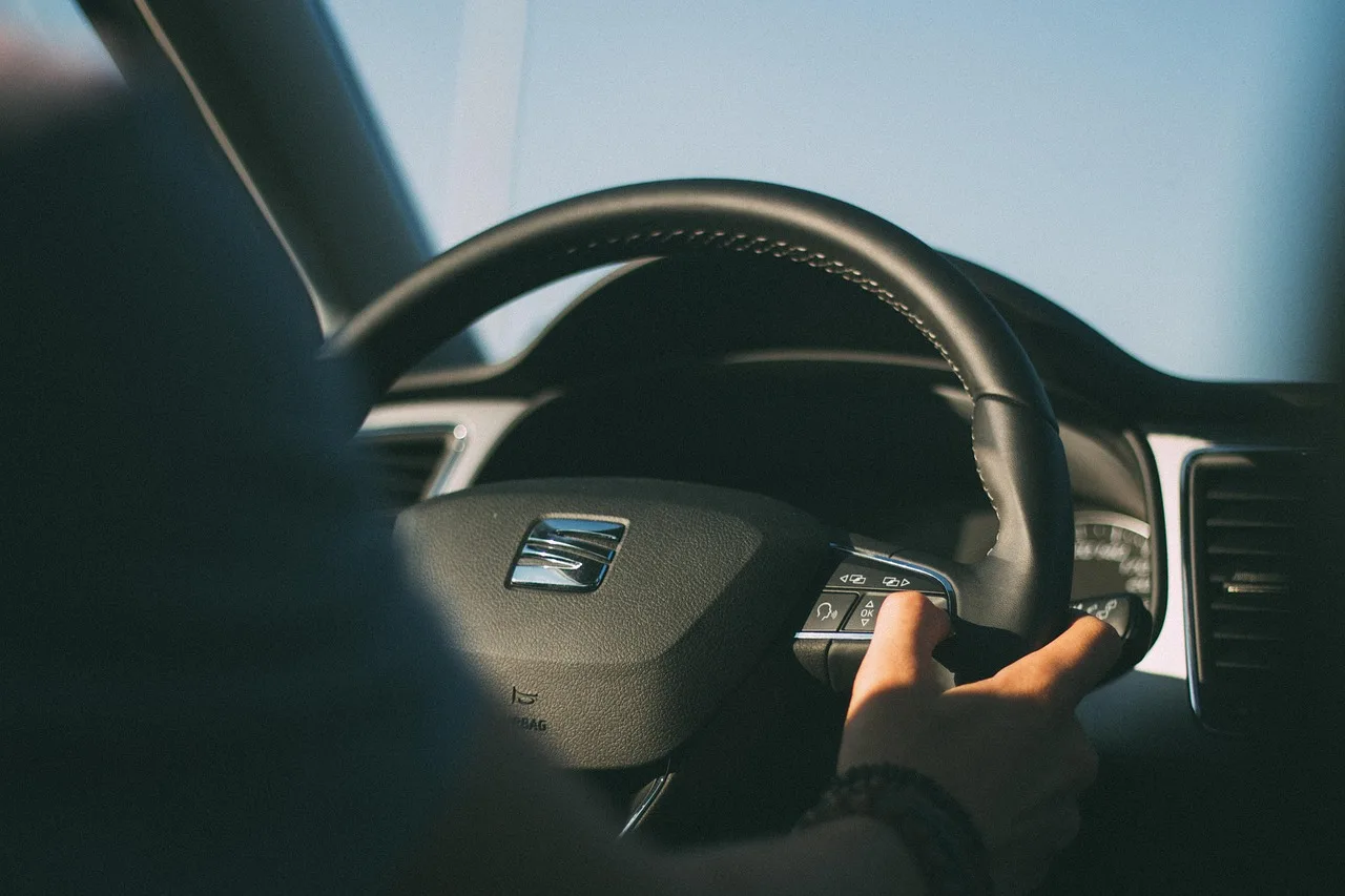 Car installer tracing steering wheel controls wiring beside an aftermarket stereo in a vehicle interior