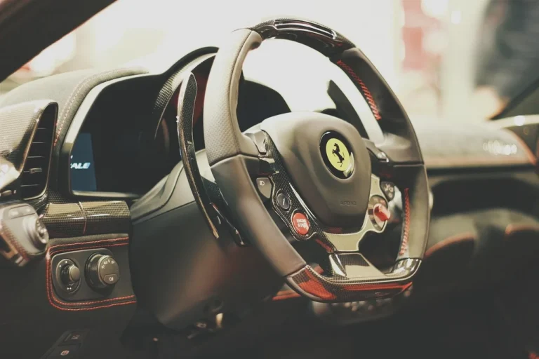 Car steering wheel controls next to a center dash stereo in a sunlit interior.
